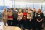 Employees wearing Christmas jumpers in the showroom against a car.